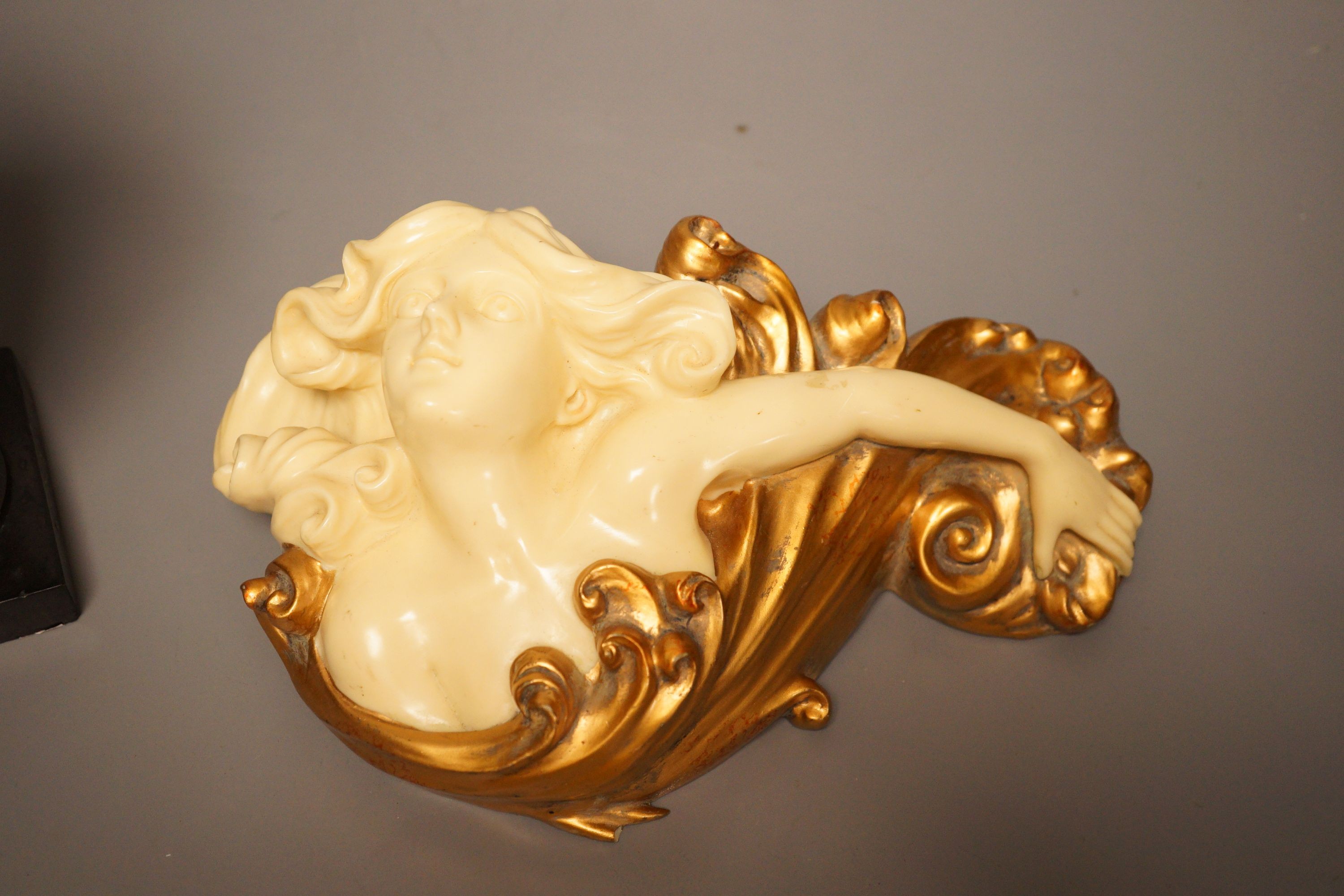 A pair of gilt resin figural wall appliques, signed, and a 19th century cast iron and slate beaker, Sotheby’s label to base, tallest 17cm